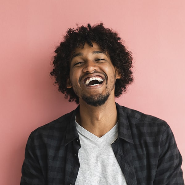 A young man with curly hair laughing 