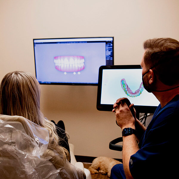 Dr. Jason showing a patient her smile on a screen