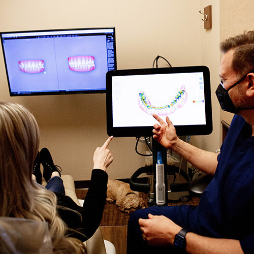 Dr. Jason showing a patient an image of her denture.