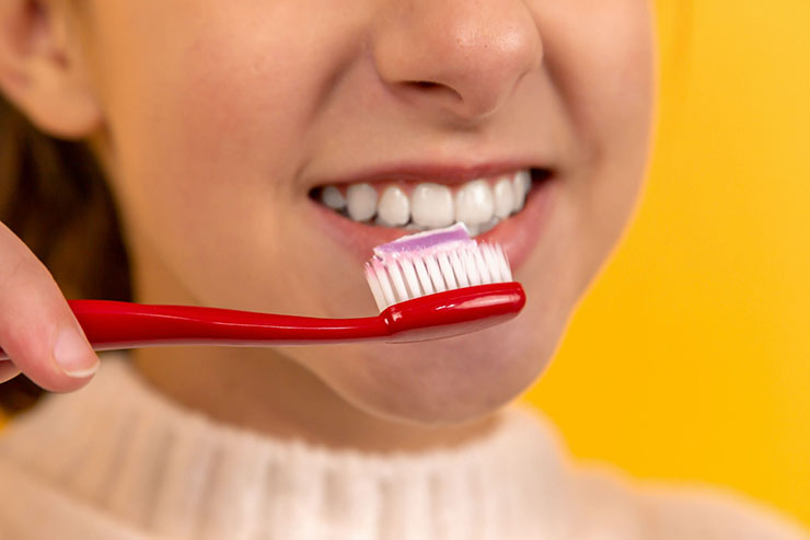 dark-haired women brushing her teeth