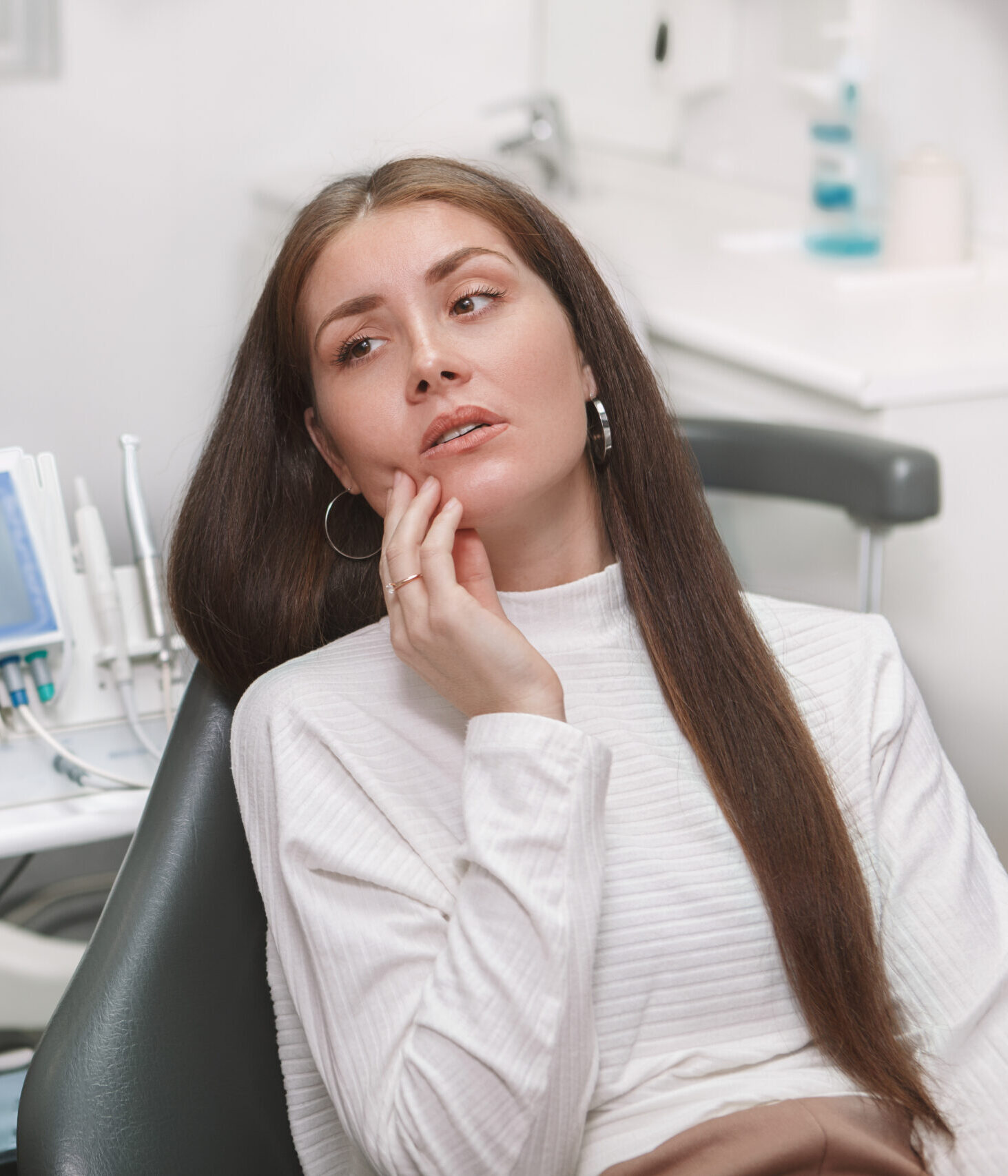 Attractive young woman having toothache, visiting dentist