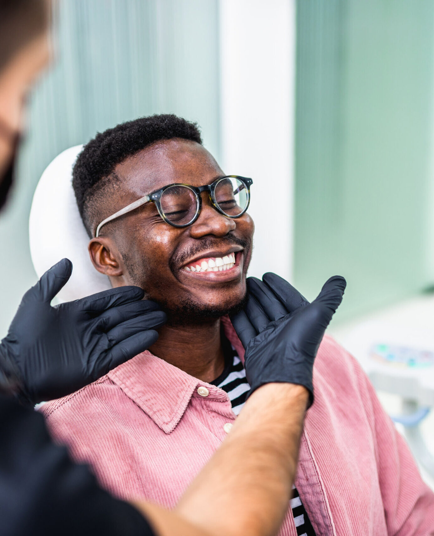African American young man having a visit at the dentist's. He is sitting on chair at dentist office in dental clinic.