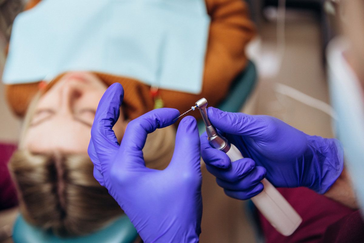 Closeup picture of dental instruments drill and needle for root canal treatment and pulpitis in hand at the dentist