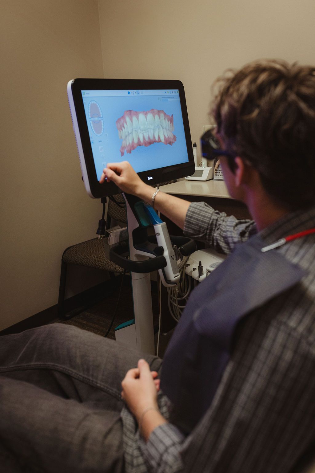 All Smiles Dentistry team member demonstrating digital dental imaging on computer screen