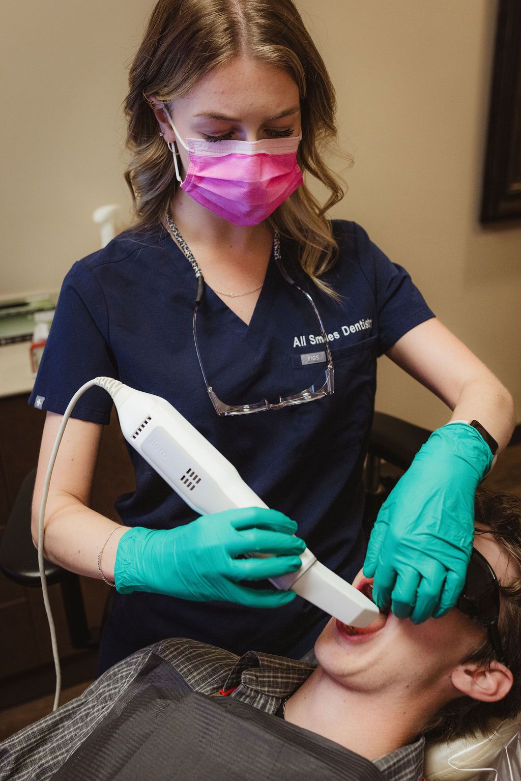 All Smiles Dentistry hygienist using ultrasonic scaler during professional teeth cleaning