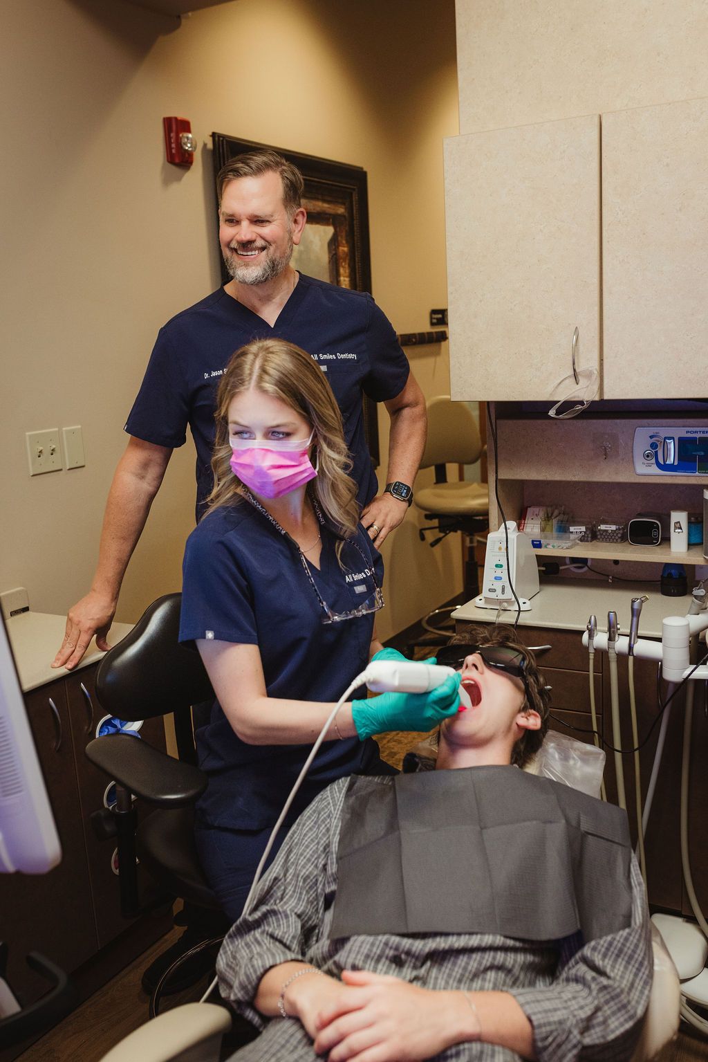 All Smiles Dentistry dentist and assistant treating young patient in dental operatory
