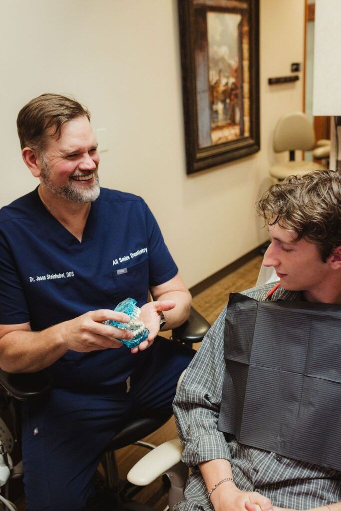 All Smiles Dentistry Dr. Jason Steidhabel shows teeth model to patient