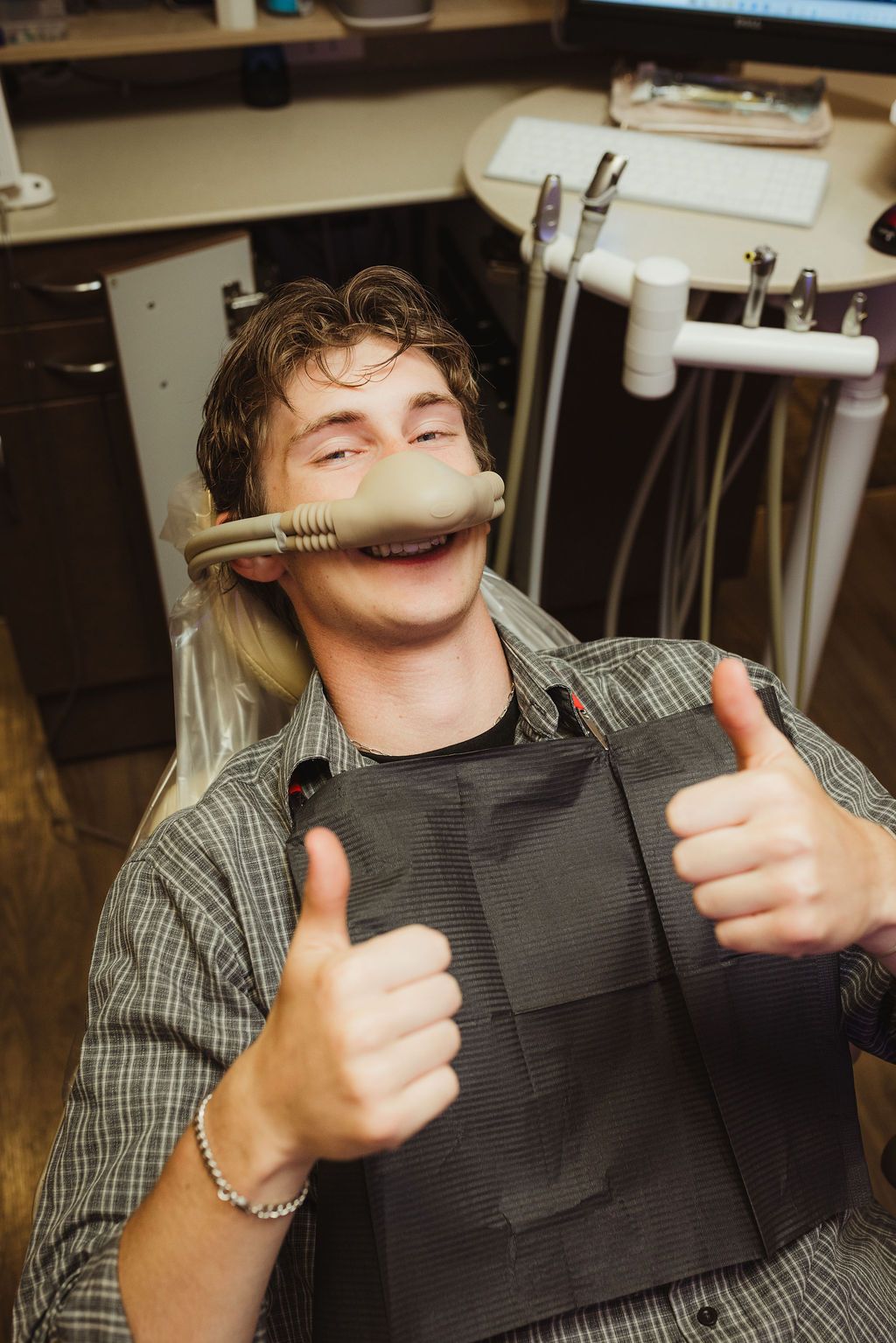 Patient giving thumbs up with intraoral scanner in All Smiles Dentistry treatment room