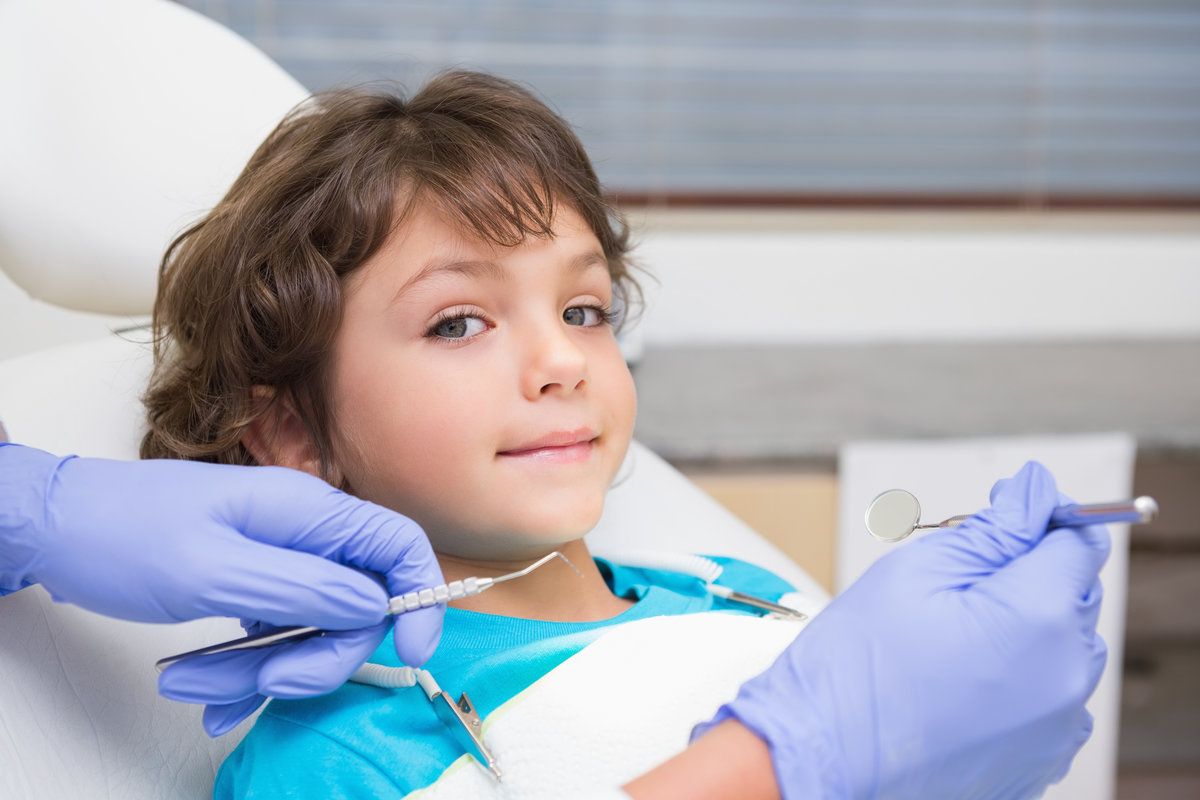 Child at dentist, smiling and relaxed.